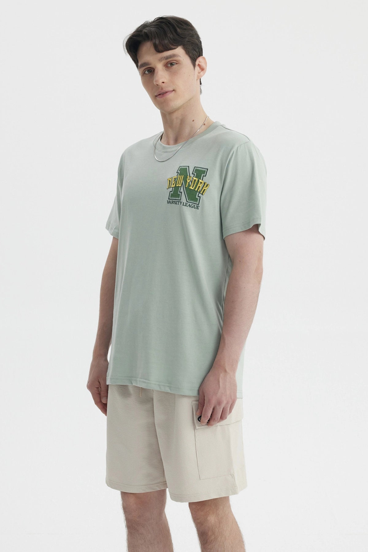 Polera oversize verde claro con bordado New York Varsity League en el pecho estilo casual relajado