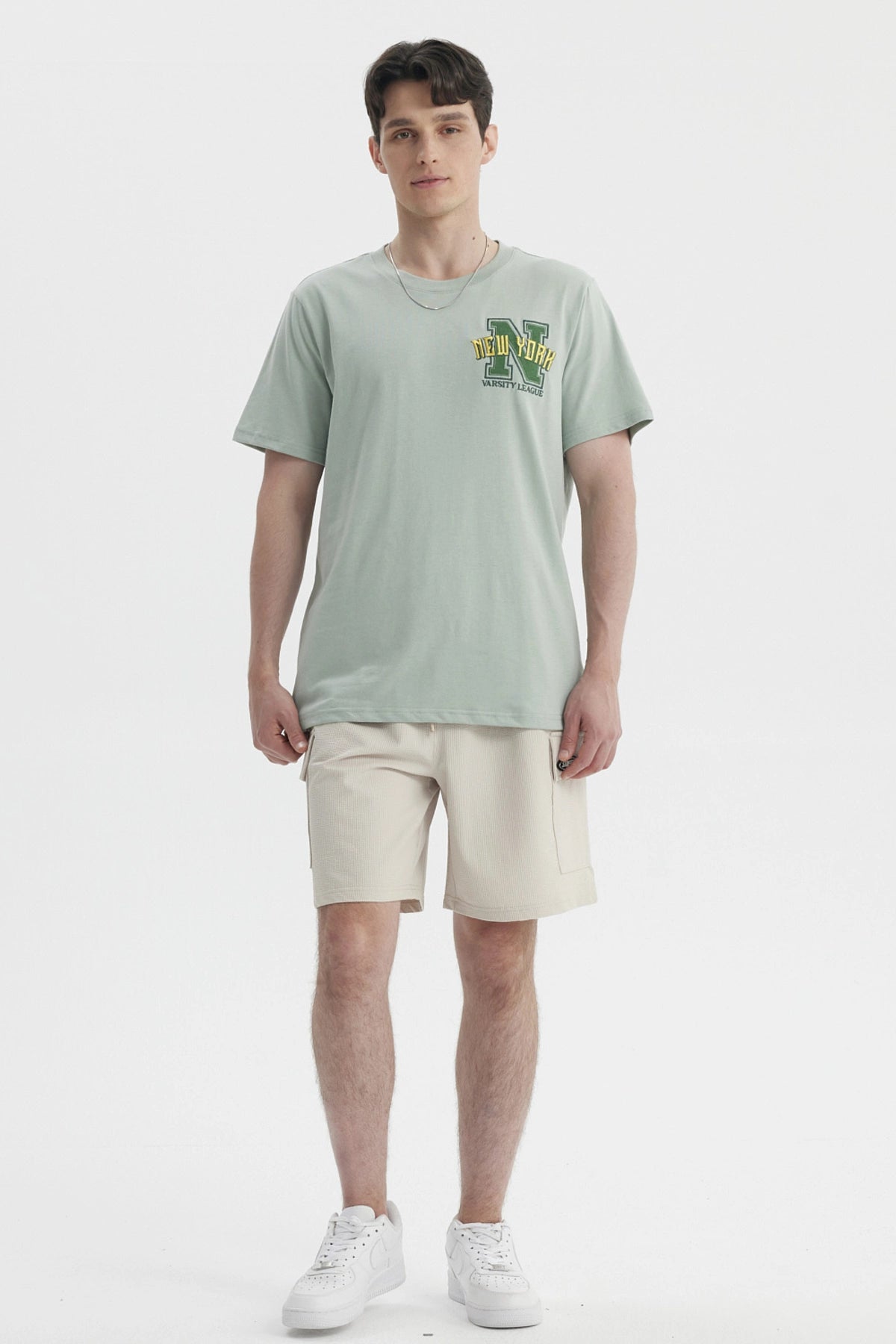 Polera oversize verde claro con bordado New York Varsity League en el pecho estilo casual relajado