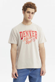 Polera oversize beige con texto rojo "Denver Athletic Dept" al frente estilo casual urbano