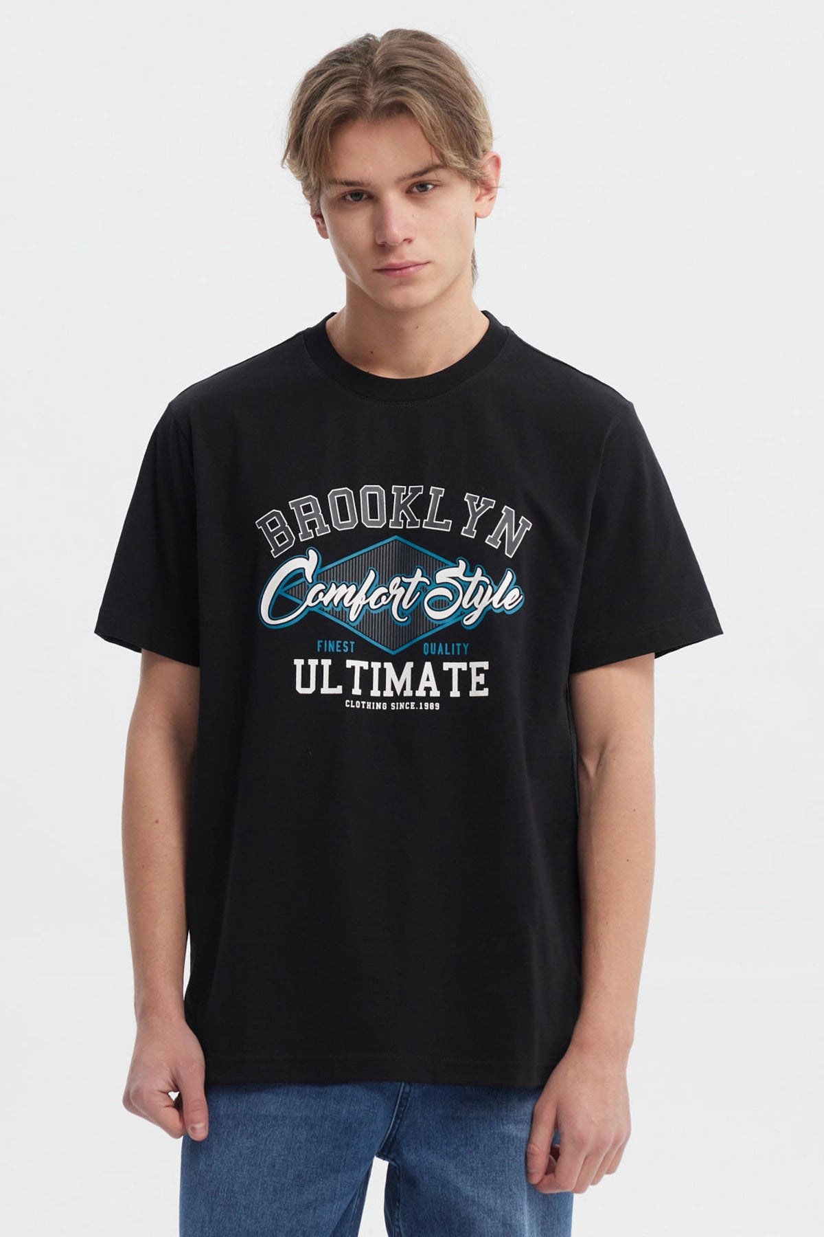 Polera negra regular fit para hombre con estampado grande al frente estilo college en letras blancas y azules