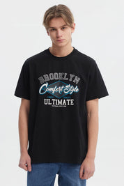 Polera negra regular fit para hombre con estampado grande al frente estilo college en letras blancas y azules