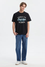 Polera negra regular fit para hombre con estampado grande al frente estilo college en letras blancas y azules