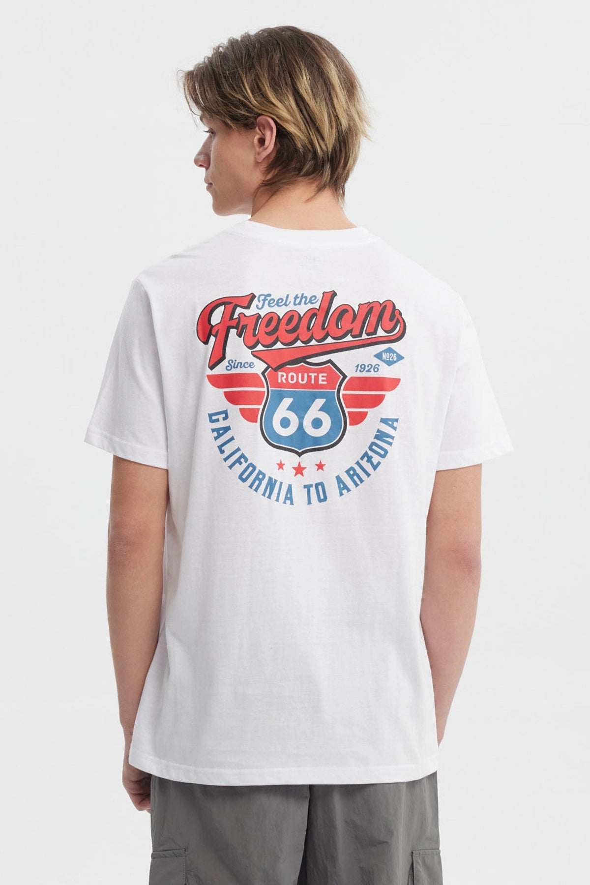 Polera blanca hombre regular fit con texto Freedom en rojo en el pecho diseño simple y moderno sin estampas traseras