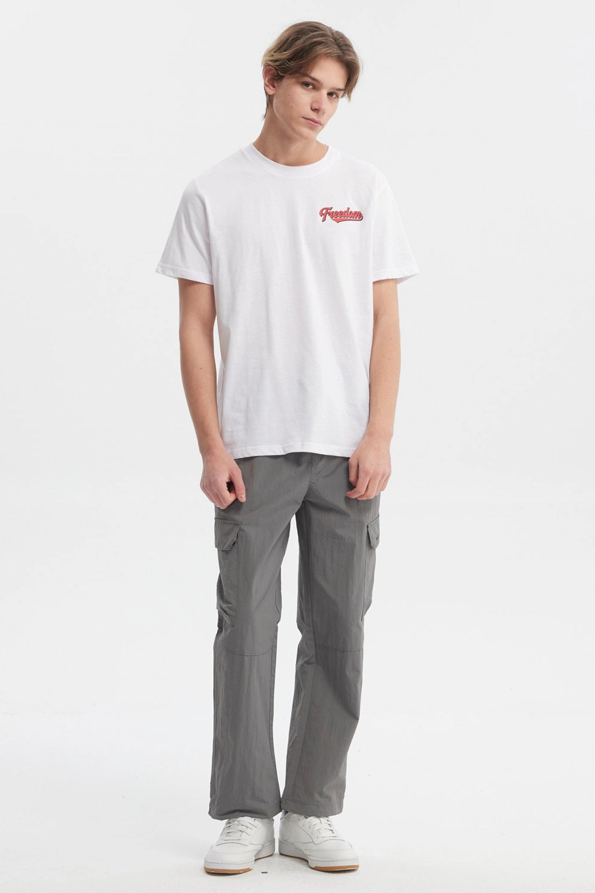 Polera blanca hombre regular fit con texto Freedom en rojo en el pecho diseño simple y moderno sin estampas traseras