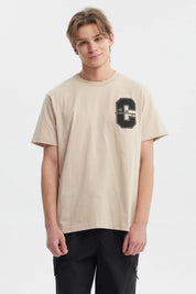 Polera beige de hombre regular fit con letra C y palabra Challenge en el pecho estilo deportivo casual