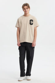 Polera beige de hombre regular fit con letra C y palabra Challenge en el pecho estilo deportivo casual