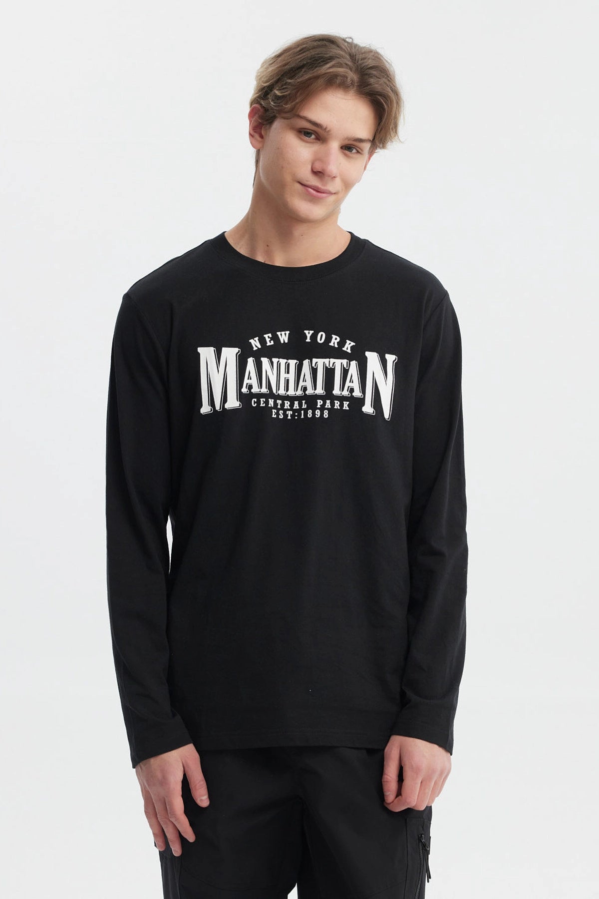 Polera negra de hombre con mangas largas y estampa grande en el frente que dice 'New York Manhattan Central Park Est 1898' en letras blancas