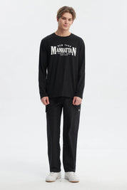Polera negra de hombre con mangas largas y estampa grande en el frente que dice 'New York Manhattan Central Park Est 1898' en letras blancas