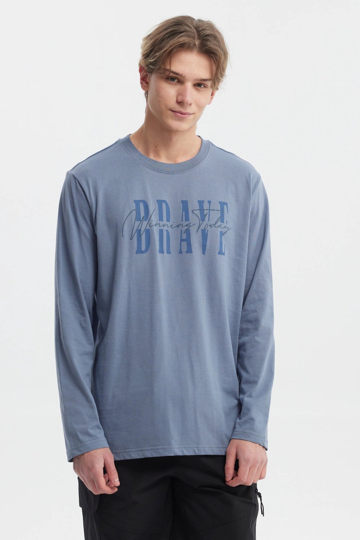 Polera de hombre azul piedra con texto BRAVE Winning Today en el pecho estilo moderno y casual ideal para el día a día