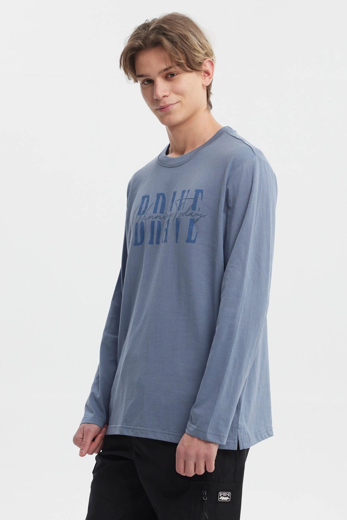 Polera de hombre azul piedra con texto BRAVE Winning Today en el pecho estilo moderno y casual ideal para el día a día