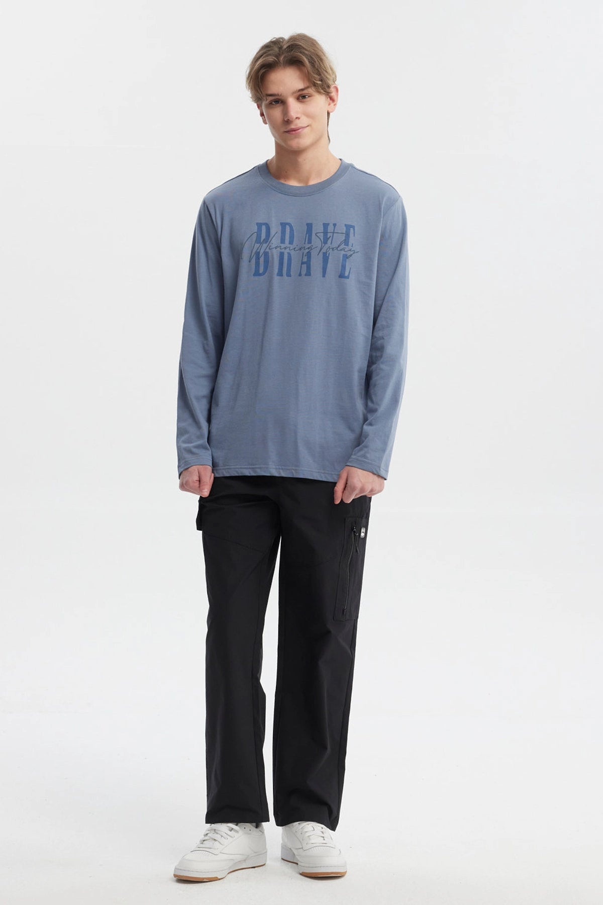 Polera de hombre azul piedra con texto BRAVE Winning Today en el pecho estilo moderno y casual ideal para el día a día
