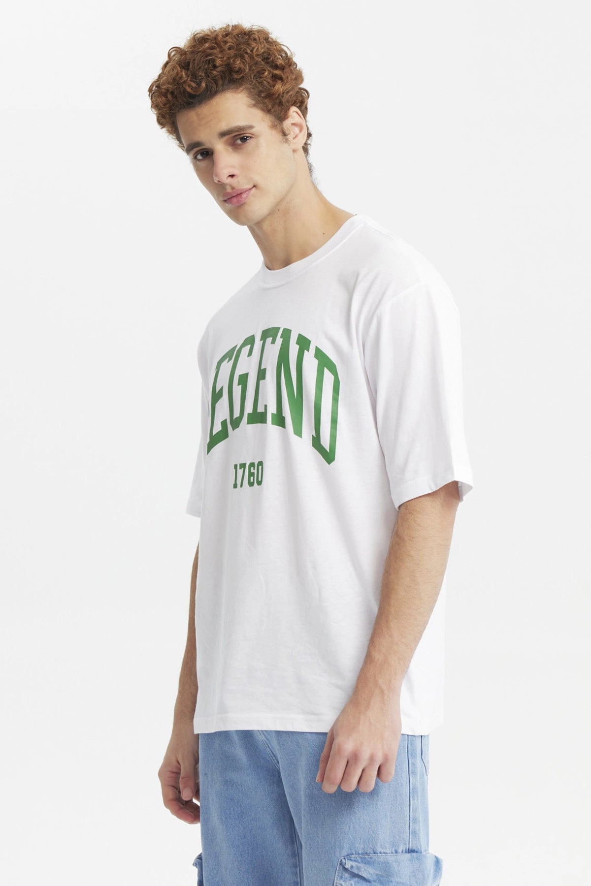 Polera oversize blanca para hombre con la palabra Legend y el número 1760 en verde al frente estilo universitario