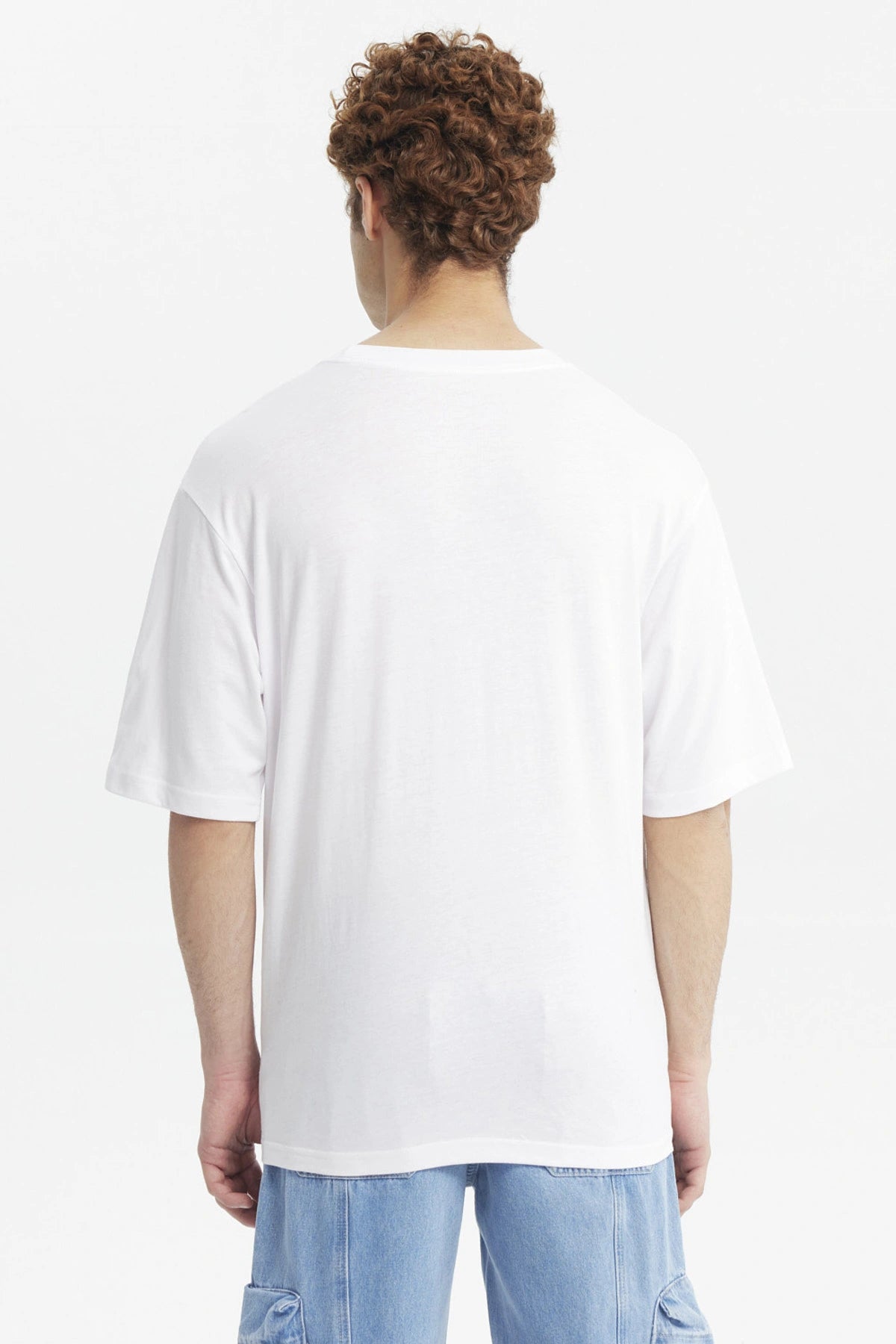 Polera oversize blanca para hombre con la palabra Legend y el número 1760 en verde al frente estilo universitario