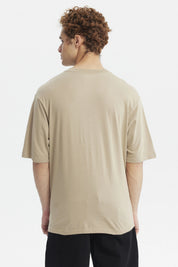 Polera oversize beige oscuro con texto Stay Awake en el pecho estilo casual relajado