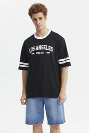 Polera negra hombre con texto Los Angeles Being Real al frente estilo urbano casual mangas con franjas blancas