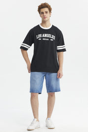 Polera negra hombre con texto Los Angeles Being Real al frente estilo urbano casual mangas con franjas blancas