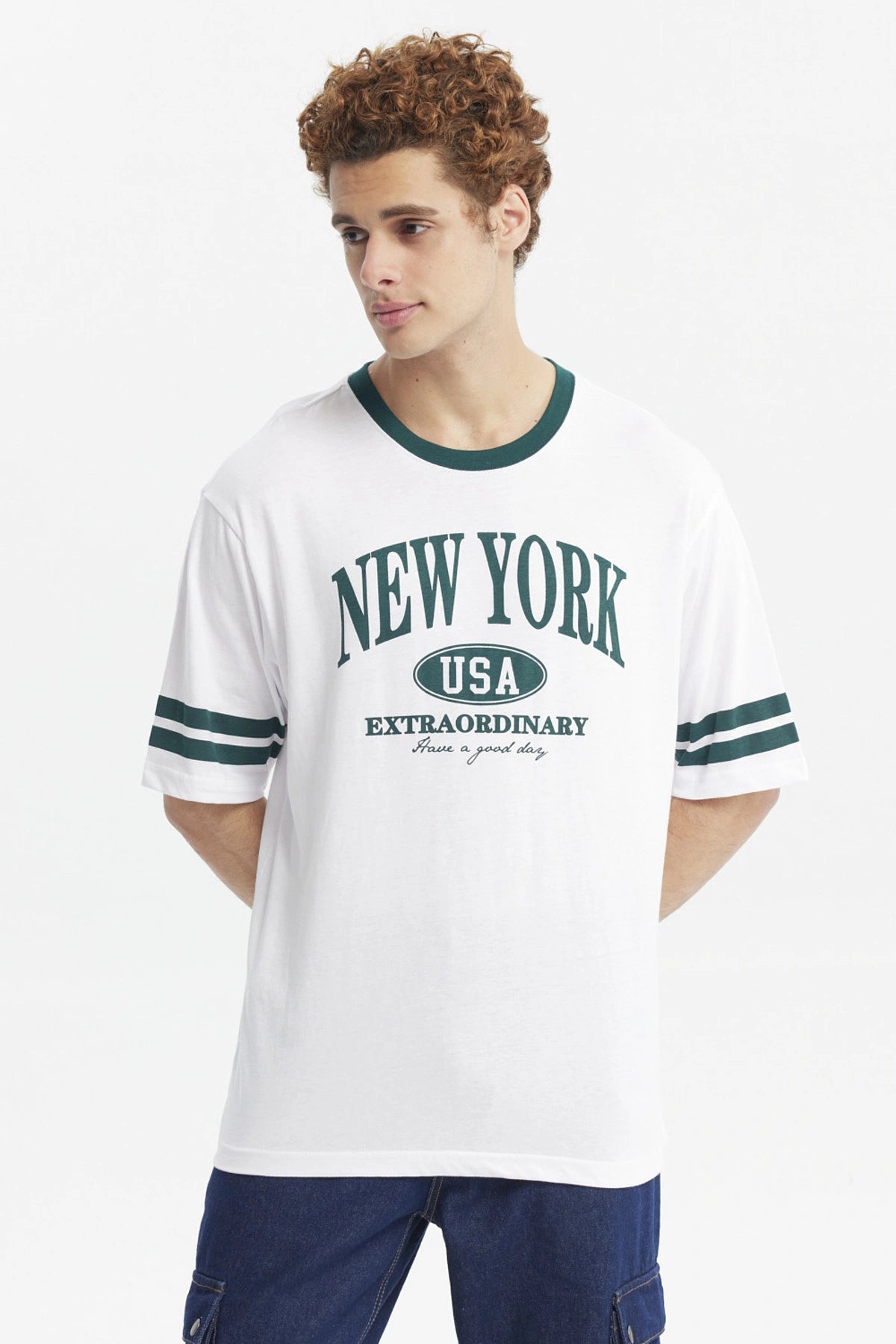 Polera blanca para hombre con texto New York USA Extraordinary en el pecho en verde y detalles de rayas en las mangas