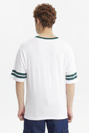 Polera blanca para hombre con texto New York USA Extraordinary en el pecho en verde y detalles de rayas en las mangas