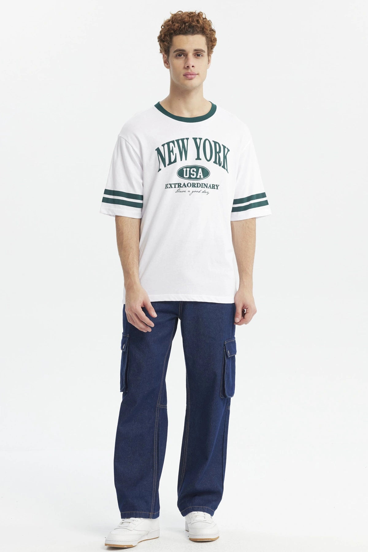 Polera blanca para hombre con texto New York USA Extraordinary en el pecho en verde y detalles de rayas en las mangas