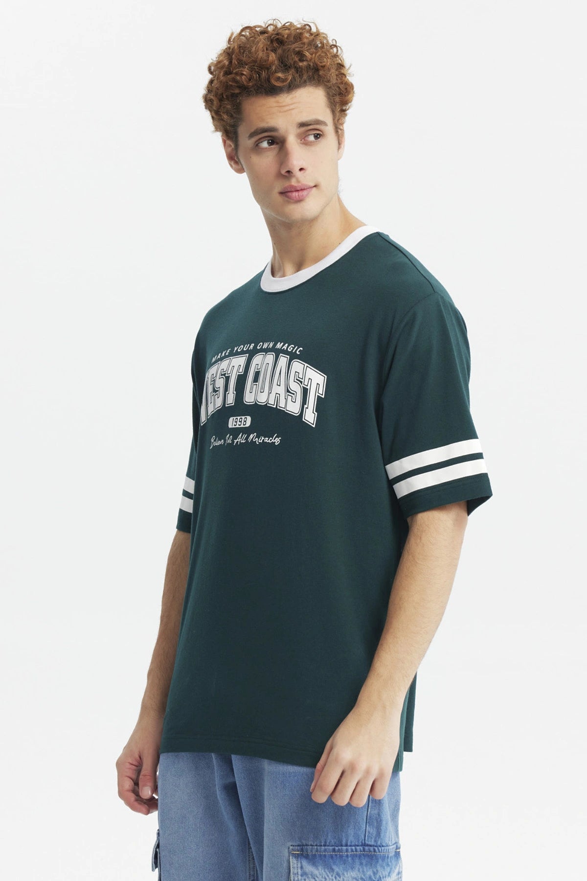 Polera verde oscuro para hombre con texto West Coast en el pecho estilo deportivo con rayas blancas en las mangas
