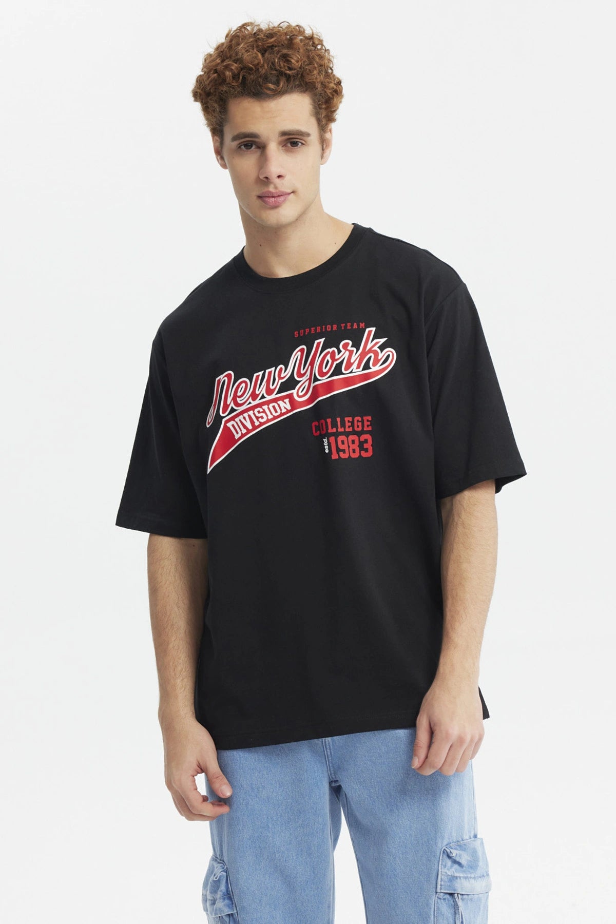Polera negra juvenil con estampado New York Division en rojo y blanco estilo universitario al frente de tamaño mediano