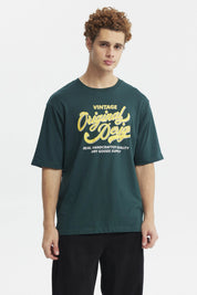 Polera juvenil verde con diseño vintage amarillo al frente texto Original Design estilo gráfico retro
