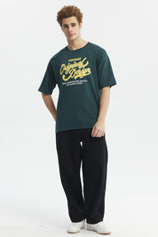 Polera juvenil verde con diseño vintage amarillo al frente texto Original Design estilo gráfico retro