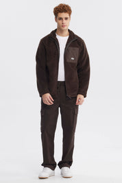 Polar juvenil slim chocolate con cierre frontal y bolsillo en el pecho con logo pequeño en fondo liso marrón oscuro