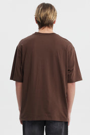 Polera slim chocolate para hombre con texto aspiracional al frente en estilo tipográfico clásico