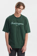Polera slim verde para hombre con texto Secret of happiness stay happy en el pecho estilo casual y relajado