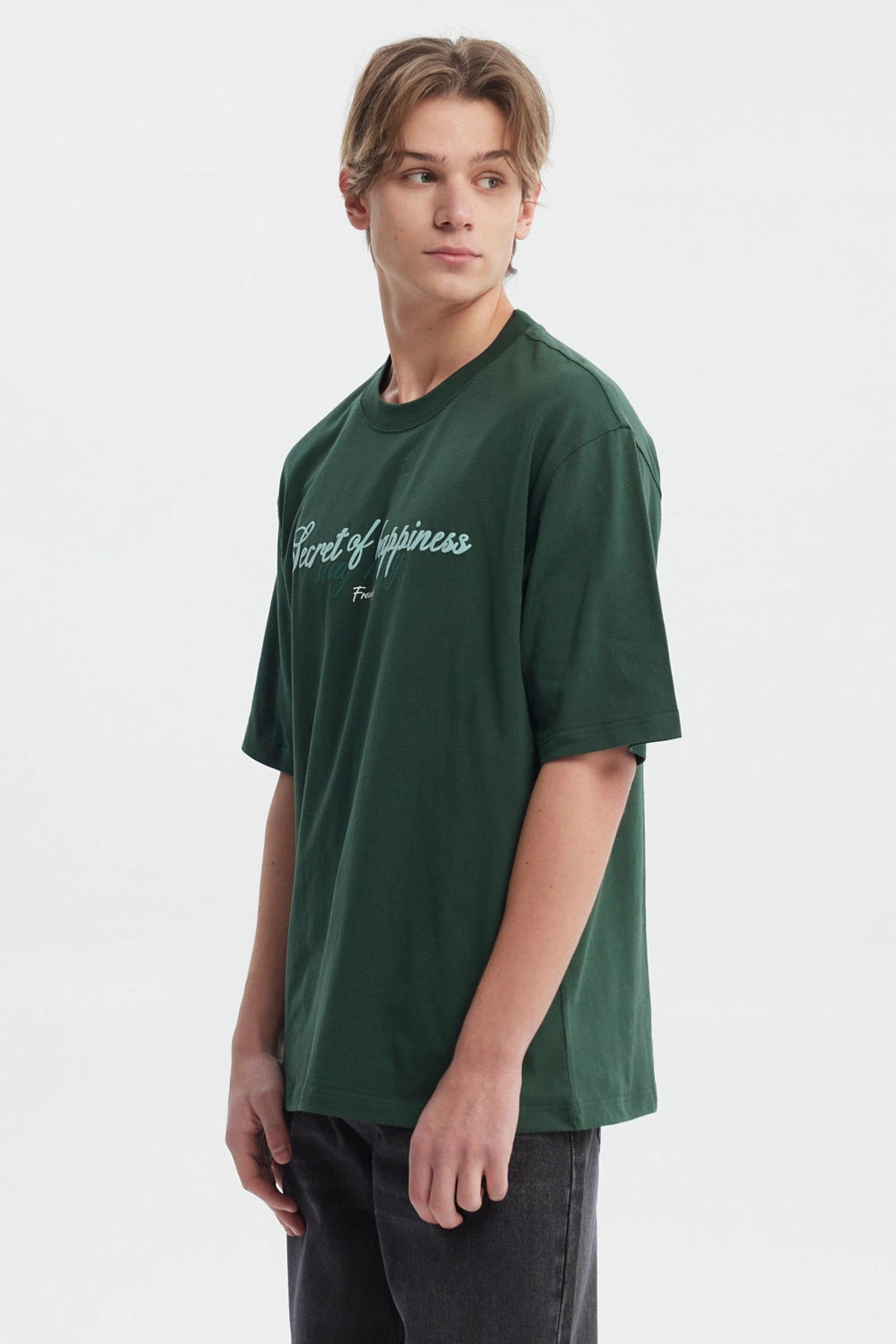 Polera slim verde para hombre con texto Secret of happiness stay happy en el pecho estilo casual y relajado