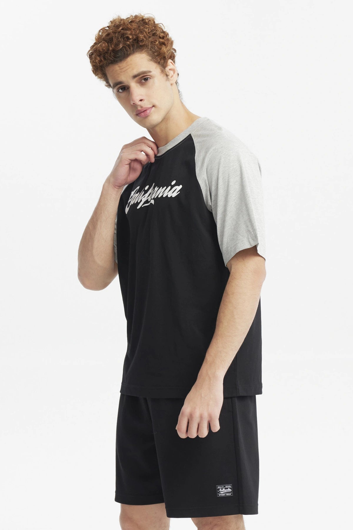 Polera negra de hombre con mangas grises y texto California en el pecho estilo casual