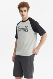 Polera hombre slim gris melange con mangas negras y estampa grande central Ascent Peaks con texto adicional Hike y Est 1989