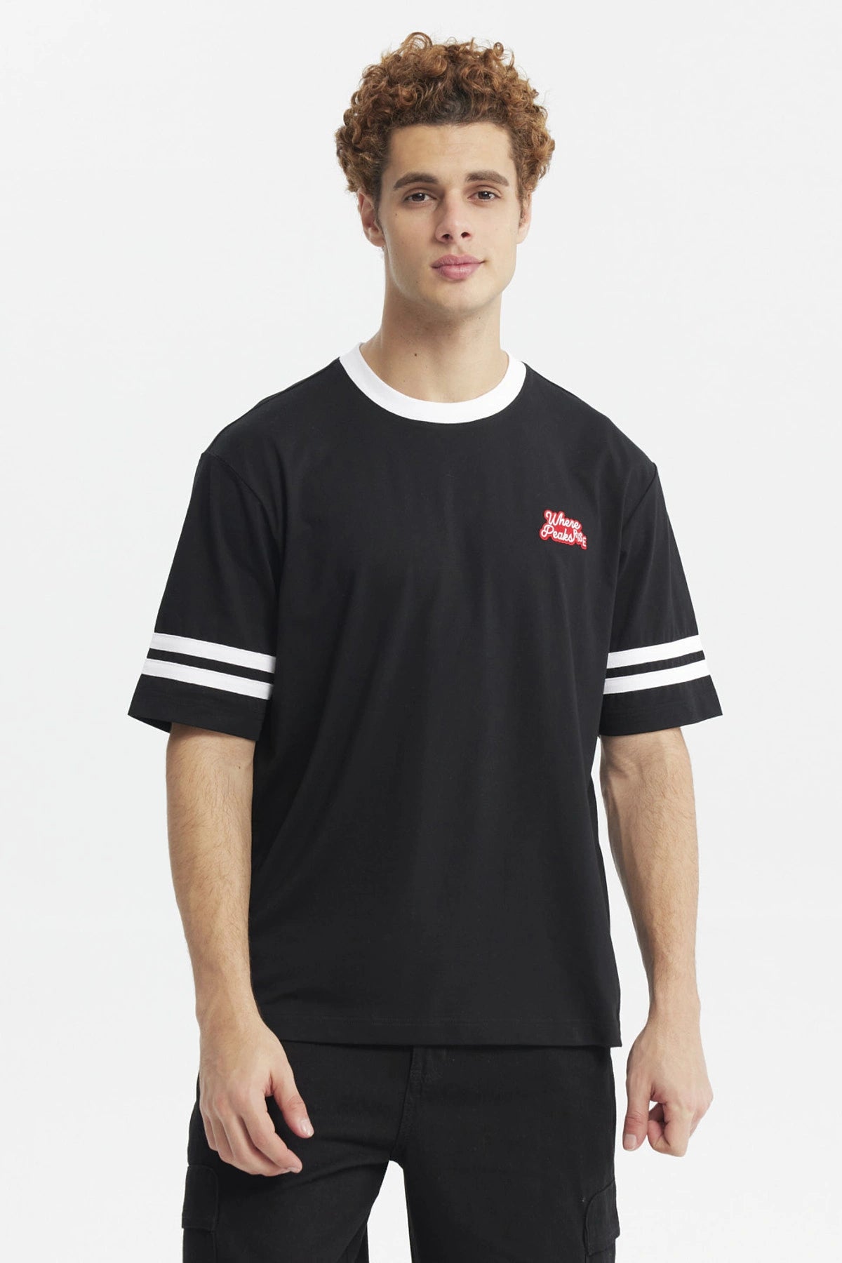 Polera oversize negra de hombre con detalles blancos en cuello y mangas estampa pequeña roja en el pecho lado izquierdo