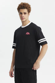 Polera oversize negra de hombre con detalles blancos en cuello y mangas estampa pequeña roja en el pecho lado izquierdo