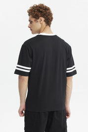 Polera oversize negra de hombre con detalles blancos en cuello y mangas estampa pequeña roja en el pecho lado izquierdo