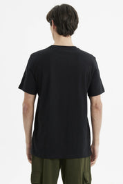 Polera negra slim fit para hombre con bolsillo al frente y estampado 'MESA' en estilo gráfico moderno