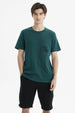 Polera slim verde oscuro con bolsillo en el pecho y texto Rock and Road en estilo gráfico pequeño y discreto