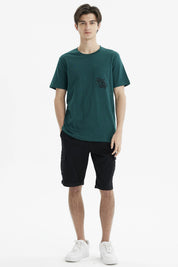 Polera slim verde oscuro con bolsillo en el pecho y texto Rock and Road en estilo gráfico pequeño y discreto