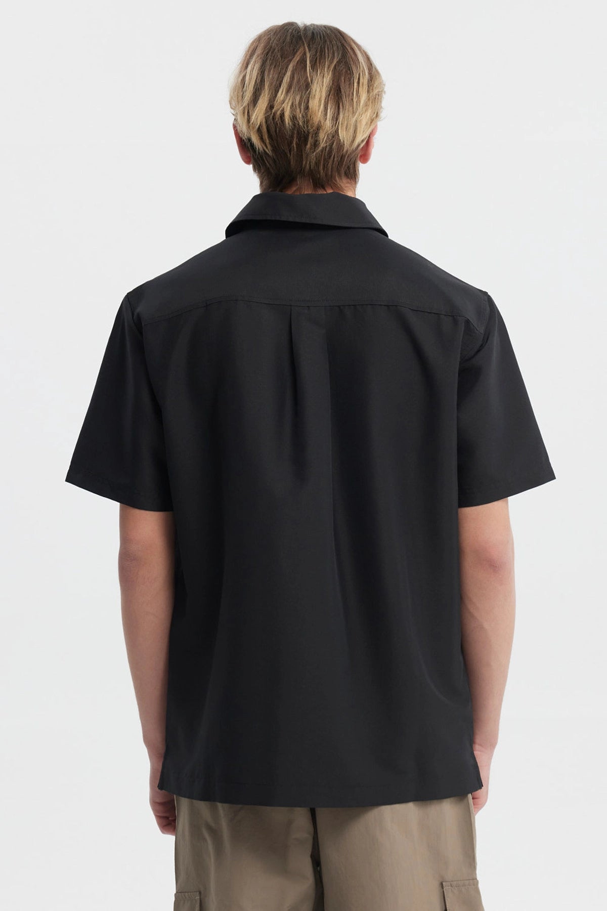 Camisa negra de hombre con doble bolsillo al frente y detalle de logo pequeño en el pecho