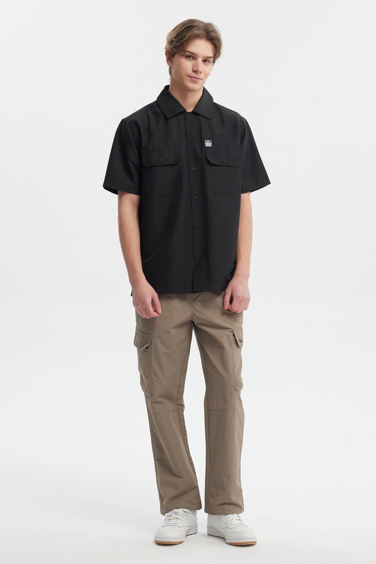 Camisa negra de hombre con doble bolsillo al frente y detalle de logo pequeño en el pecho