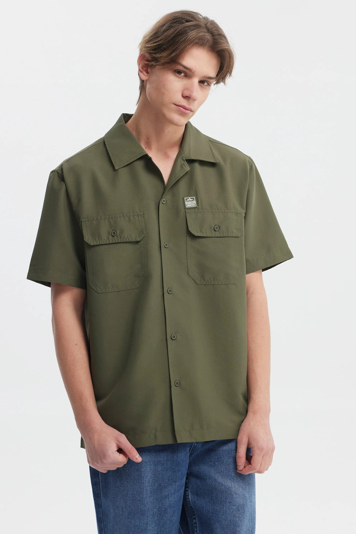 Camisa verde militar para hombre con doble bolsillo al frente y detalle de logo en el pecho diseño casual y relajado