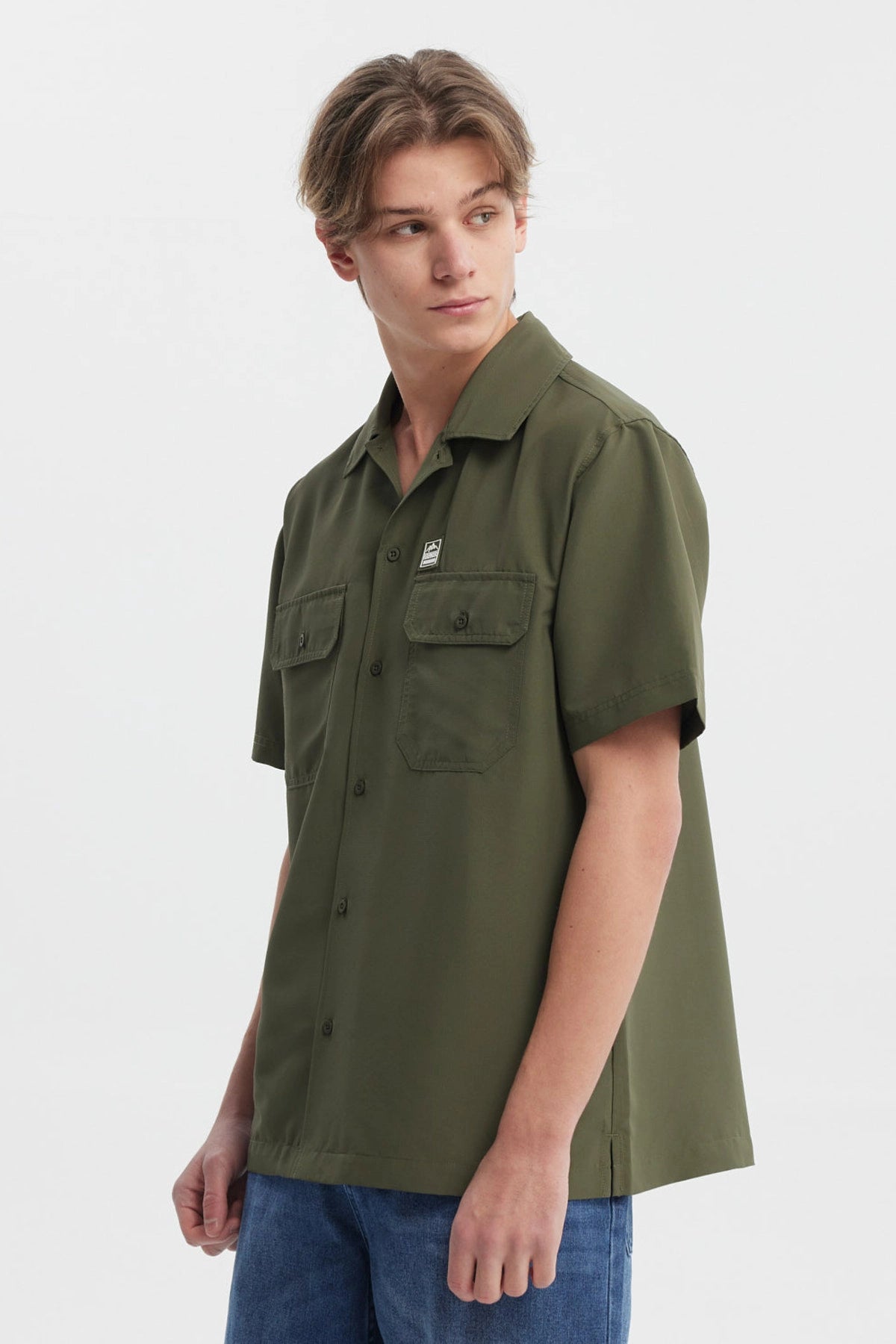 Camisa verde militar para hombre con doble bolsillo al frente y detalle de logo en el pecho diseño casual y relajado