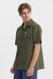 Camisa verde militar para hombre con doble bolsillo al frente y detalle de logo en el pecho diseño casual y relajado