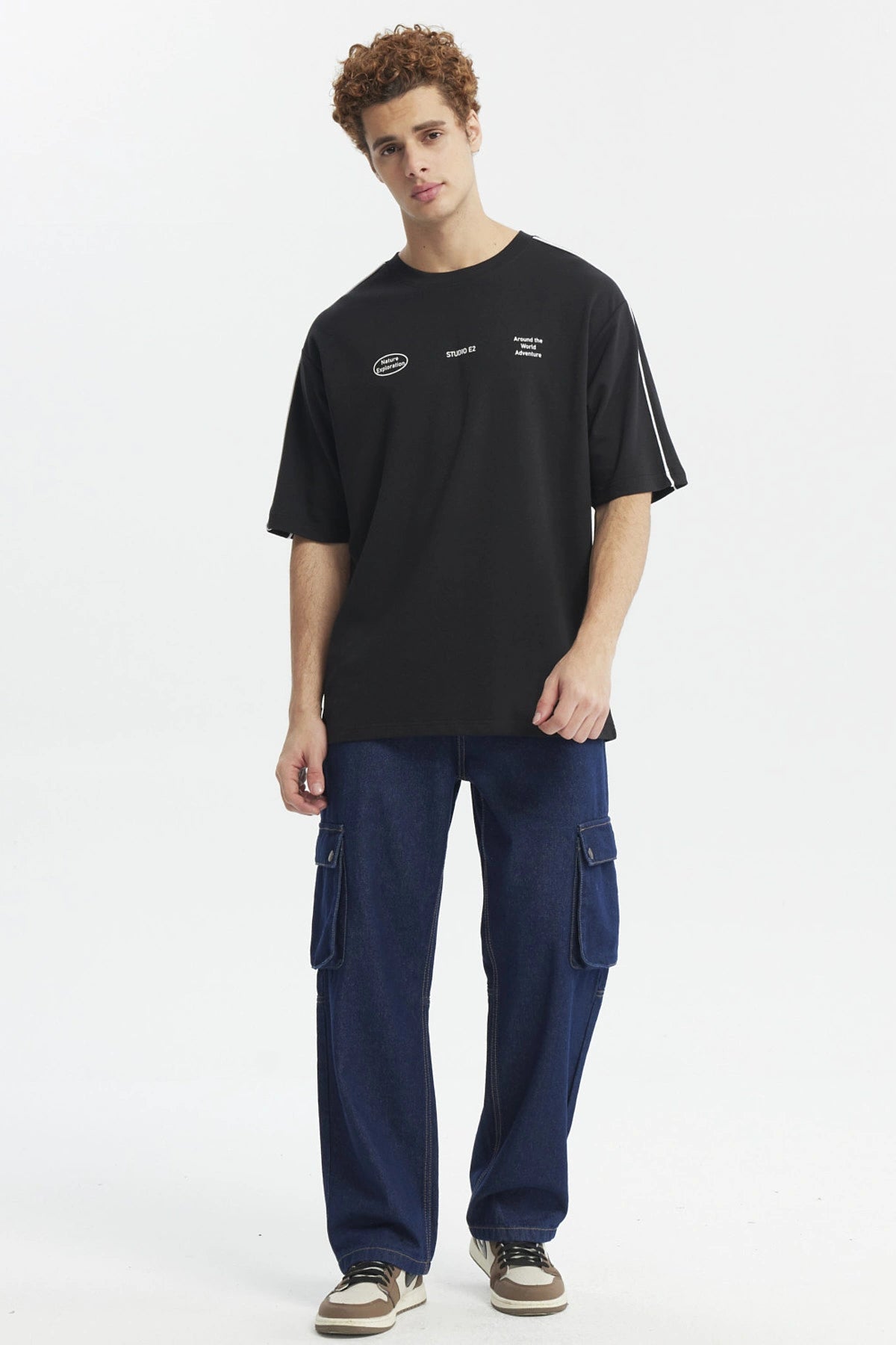 Polera negra oversize con doble línea blanca en mangas y estampado gráfico de texto pequeño en el pecho