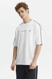 Polera oversize blanca con líneas negras en los hombros y texto Make It Count en el pecho diseño minimalista