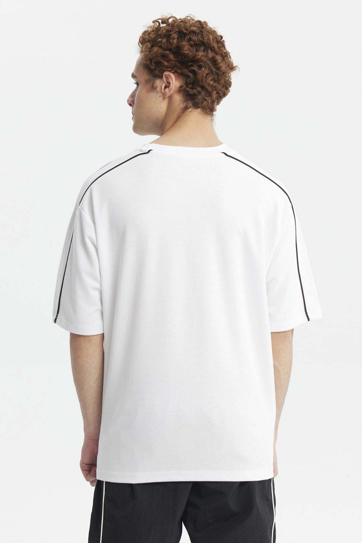 Polera oversize blanca con líneas negras en los hombros y texto Make It Count en el pecho diseño minimalista