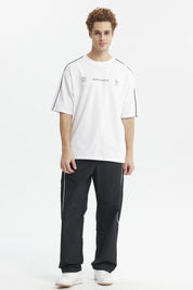 Polera oversize blanca con líneas negras en los hombros y texto Make It Count en el pecho diseño minimalista