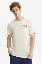 Polera slim beige hombre con texto Seattle en el pecho diseño urbano minimalista y fondo liso