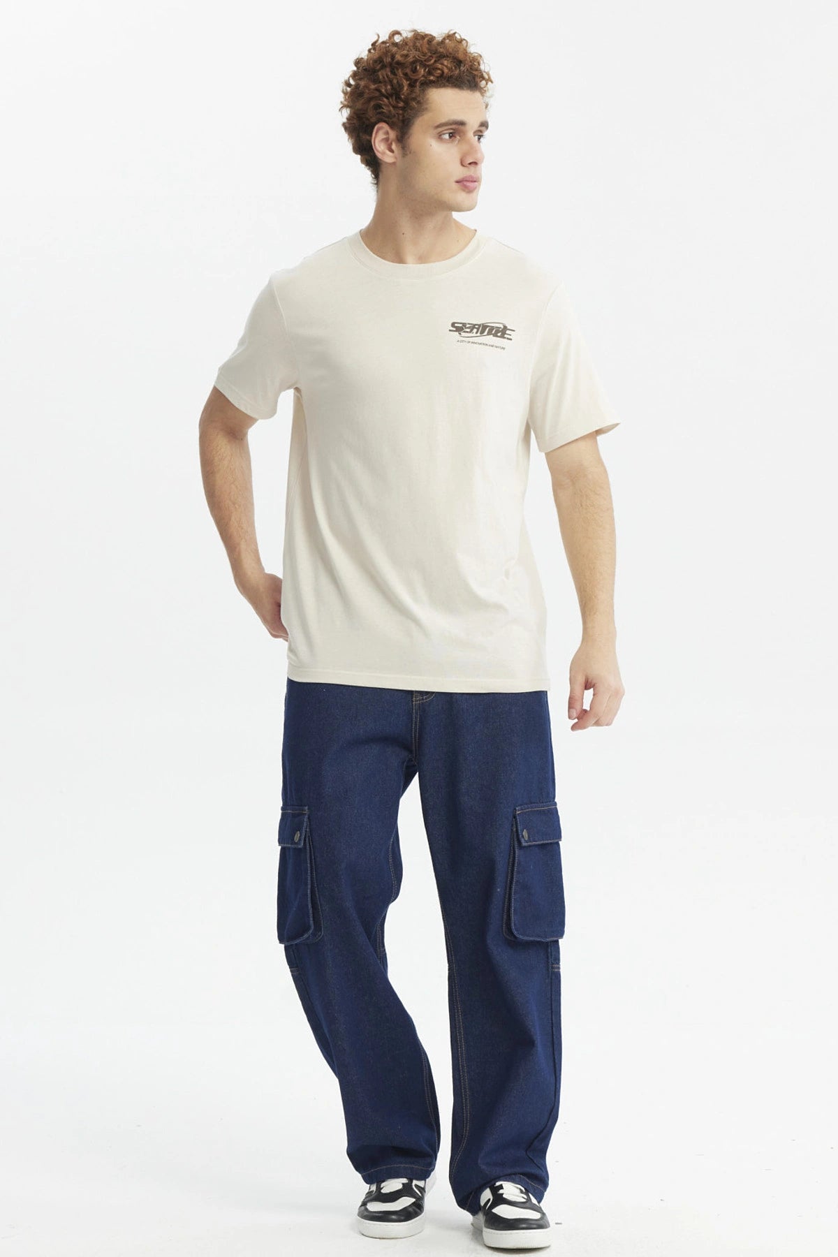 Polera slim beige hombre con texto Seattle en el pecho diseño urbano minimalista y fondo liso